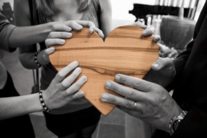 people holding a heart in healing circle